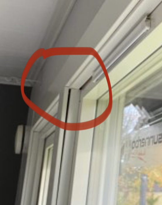 Bristfälligt monterat fönster med glipor vid hörnet markerat med röd cirkel, indikerar dåligt hantverk.
