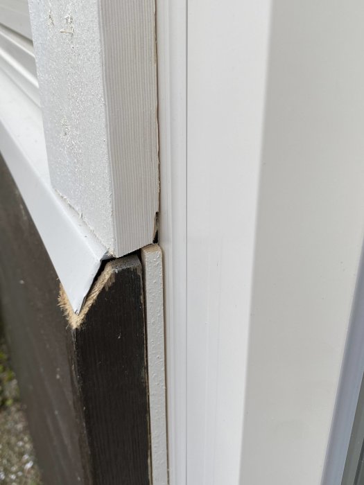 Närbild på ett fönsterbleck med pålagda bitar, under vitmålad fönsterkarm.