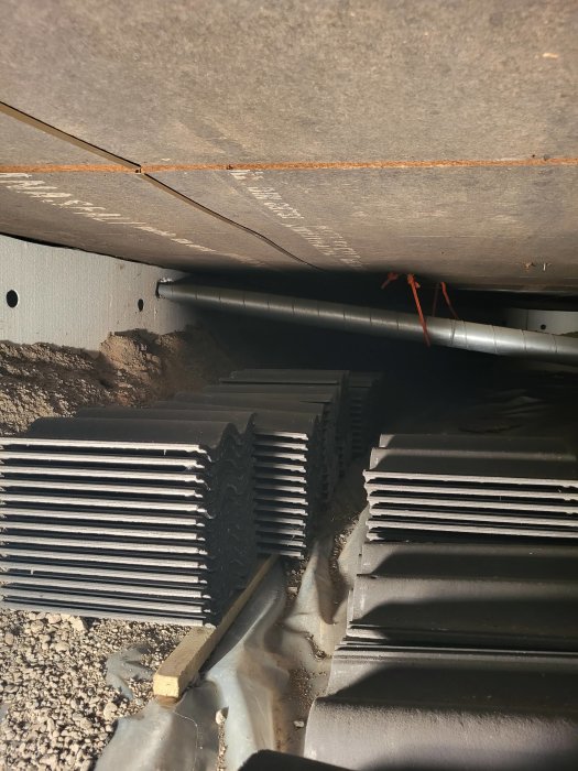 Krypgrund med förstärkt fundament och synliga ventilationsskorstenar, dåligt drag i kamin indikeras.