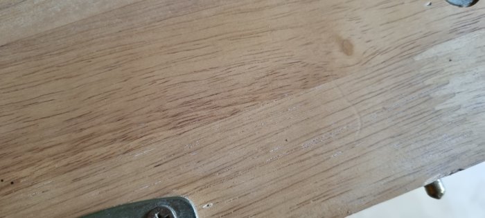 Närbild på ett träbord med synliga träfibrer och slitagespår.