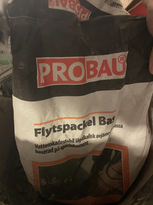 En förbrukad säck med PROBAU Flytspackel Bas som ser använd och dammig ut.