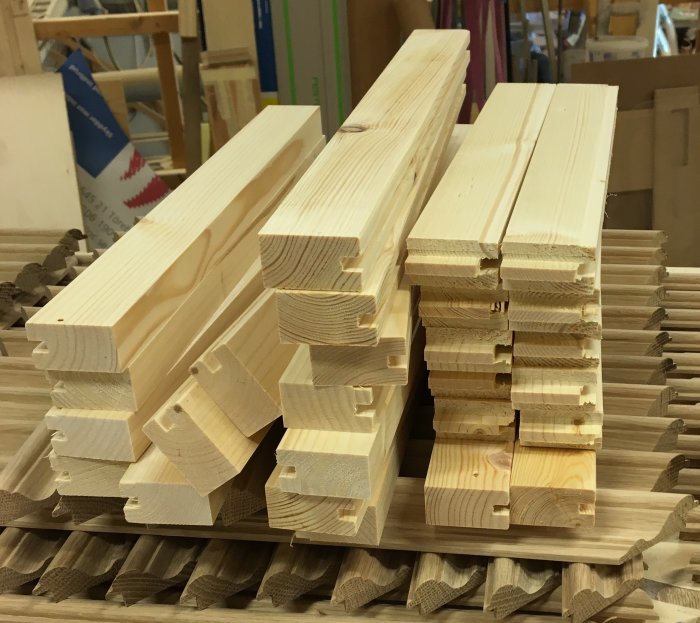 Travade trästycken förberedda för skåpsbygge med utfrästa tappar och spår.