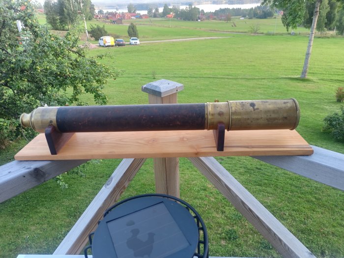 Antik marinkikare med patina vilande på handgjort träställ ute på en veranda.