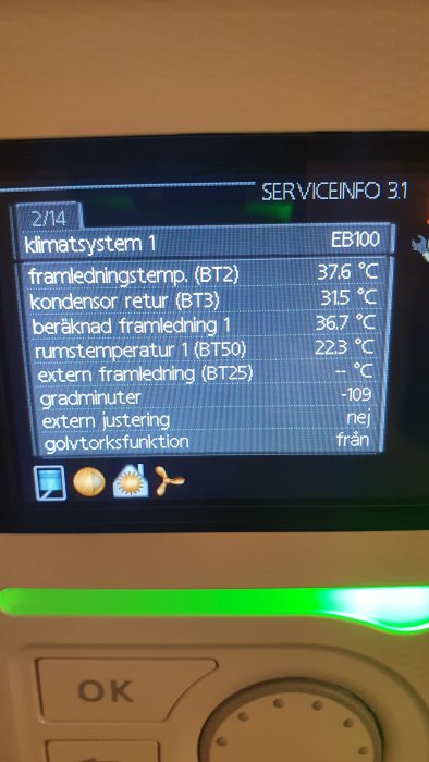 LCD-display på en värmepump som visar temperaturvärden och systeminställningar.