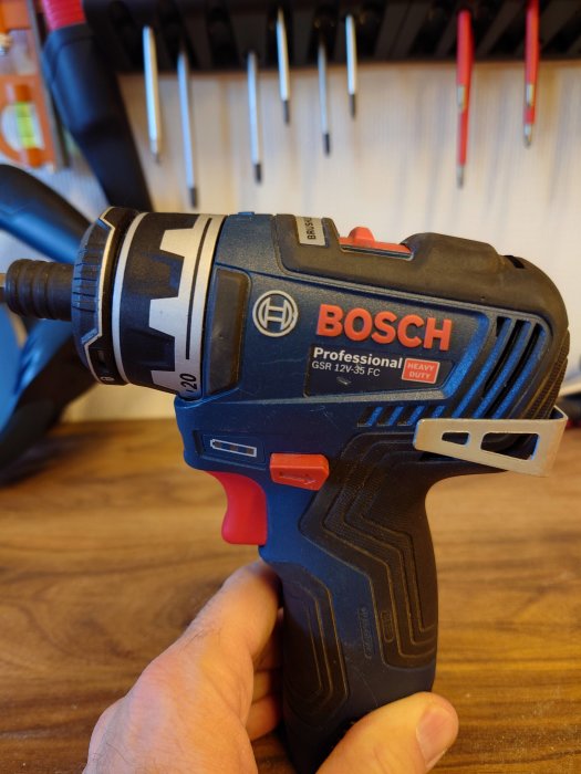 Hand håller en Bosch Professional borrmaskin med långt borrbitsfäste.