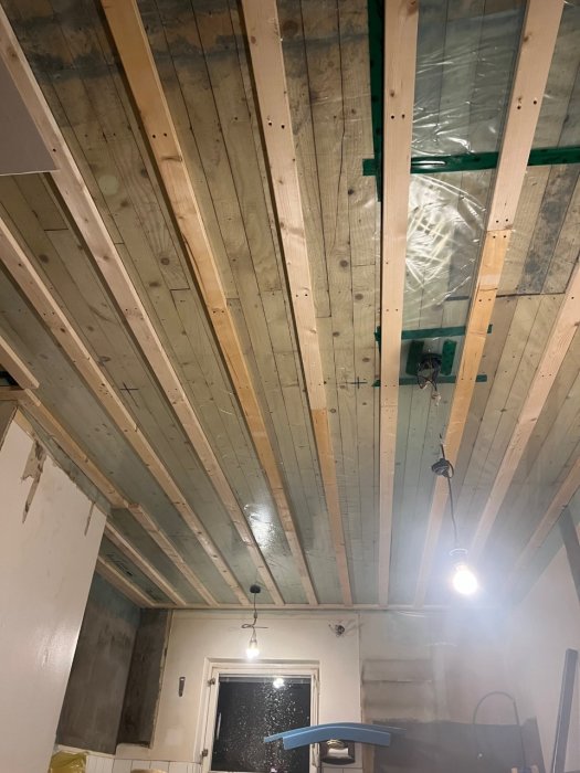 Delvis isolerad takstom i renoveringsfas med synliga träbjälkar och elinstallation.