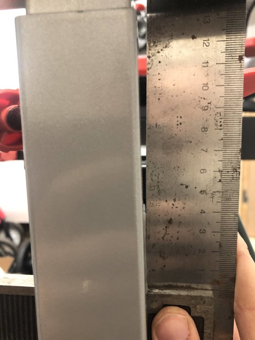 Mätning av tjocklek på en metallbalk med en skjutmått.