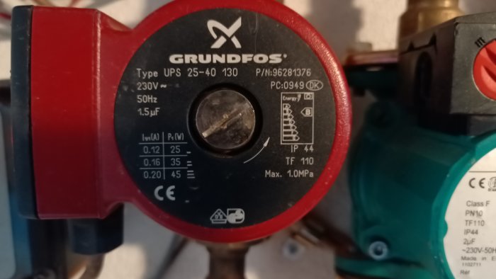 Närgrbild av en Grundfos cirkulationspump med specifikationsetiketter, indikerar problem med värme cirkulationen.