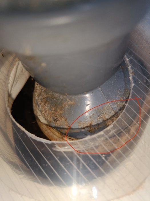 Grå PVC-förminskning som inte sitter ordentligt i köksavloppet, med läckage vid skarven.