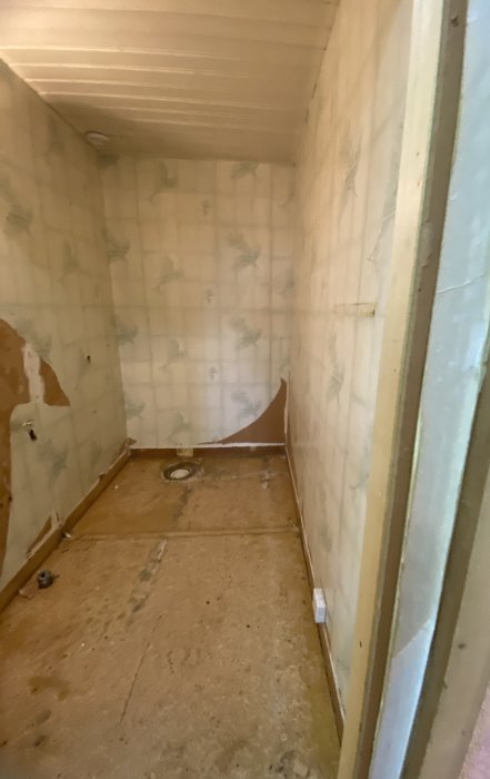 Renoveringsprojekt av badrum med borttagna sanitetsobjekt och synlig golvavlopp.