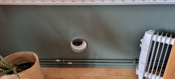 Isolerat flexrör installerat genom vägg bredvid radiator, avser förbättra luftcirkulationen.