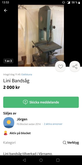 En Lini bandsåg till salu placerad framför en vit bakgrund i en verkstad.