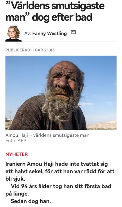 Äldre man med smutsigt ansikte och otrimmat skägg mot en suddig bakgrund av himmel och landskap.