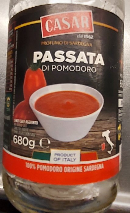 Flaska med passerade tomater, etikett visar "CASAR PASSATA DI POMODORO" och "100% POMODORO ORIGINE SARDEGNA".