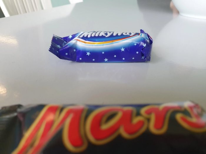 Ett Milky Way-godis på en yta framför ett Mars-godis, skämtsamt liknande Vintergatan från Mars.