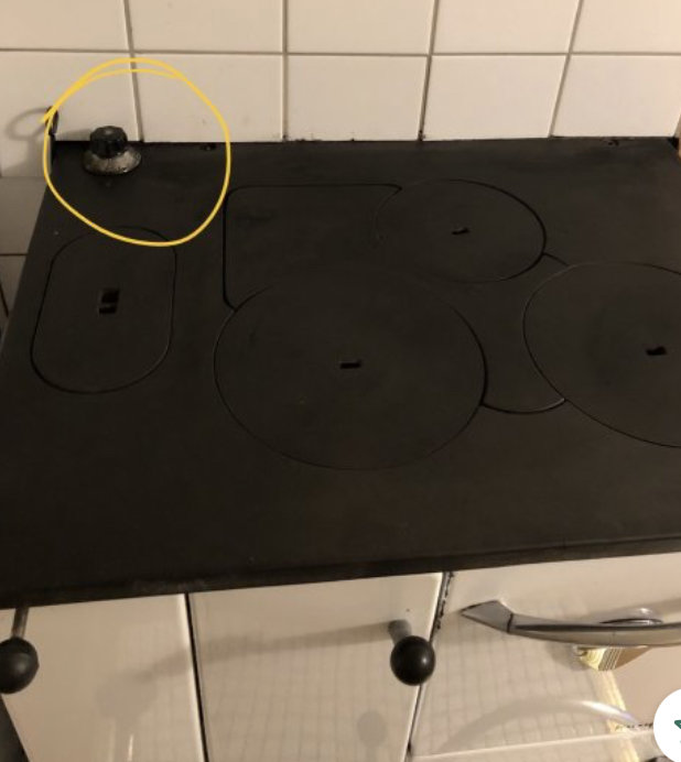 Svart spishäll med fyra kokplattor, en markerad med gul cirkel där en spisknapp saknas.