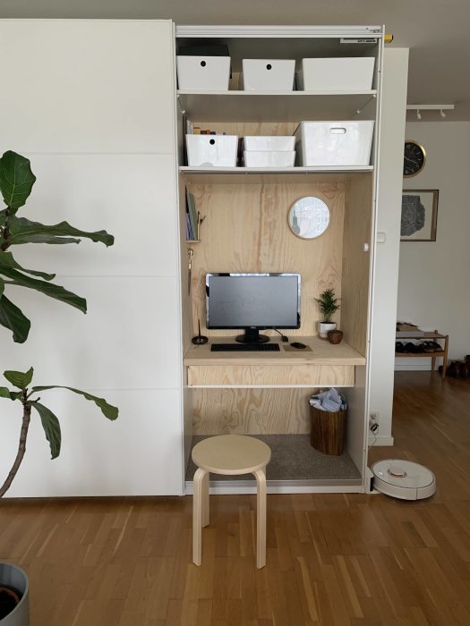 Ikea-garderob ommöblerad till hemmakontor med dator och förvaringslådor.