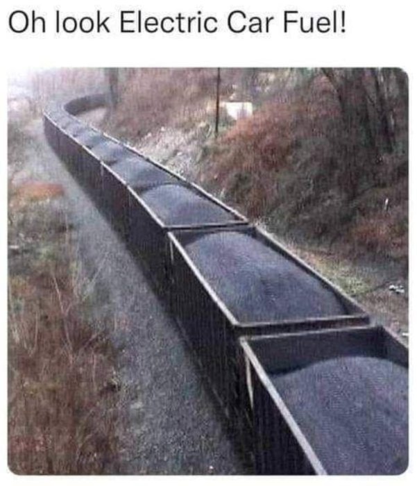 Lång tågvagn full med kol på ett järnvägsspår, med ironisk referens till elbilsbränsle.