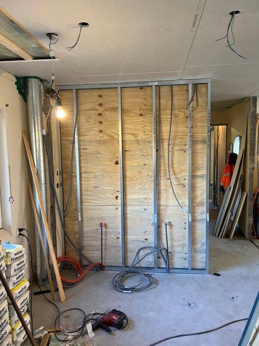 Renoveringsprojekt som visar dragning av elkablar och installationer i en oavslutad köksvägg i en byggarbetsplats.