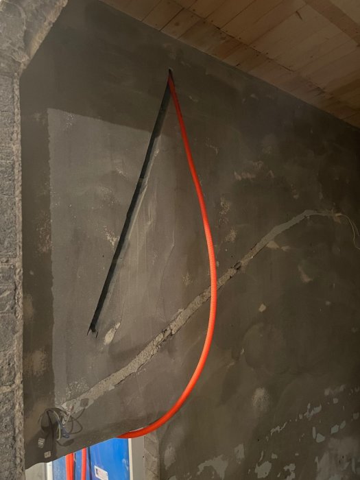 El-, signal- och patchkabel dragning längs en rå betongvägg i ett pågående köksrenoveringsprojekt.