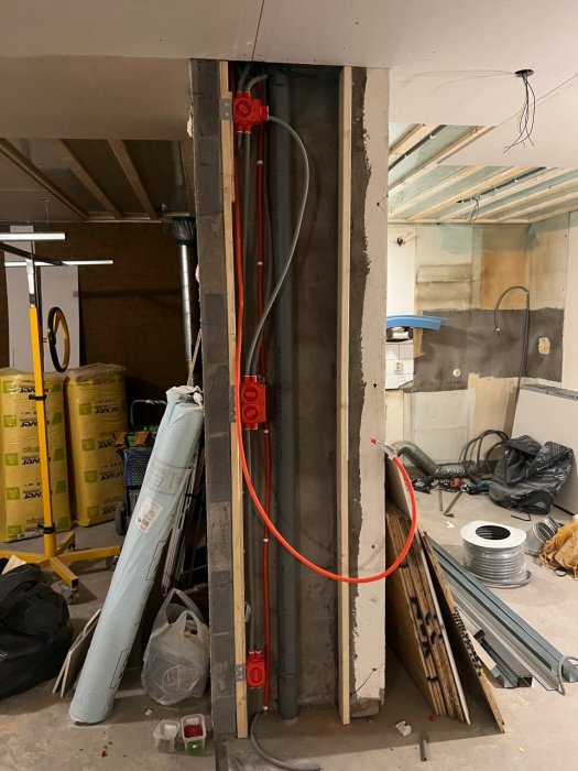 Öppen köksväggssektion med nylagda el-, signal- och patchkablar och eluttag i en pågående renovering.