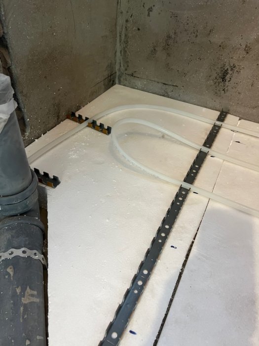 Installation av 80mm cellplast och 12mm golvvärmeslang i ett badrum inför gjutning.