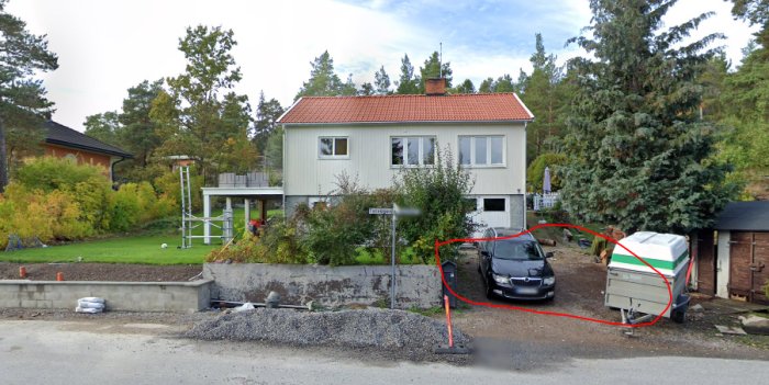 Vy över ett hus med markerad potentiell väg för avlopp genom trädgården, indikerar höjdnivåer och utmaningar.