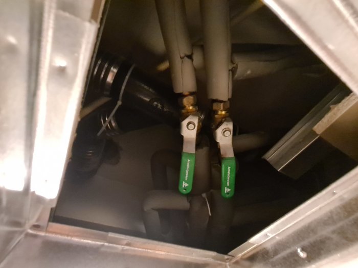 Inuti ett ventilationsaggregat med synliga rör och avstängningsventiler.