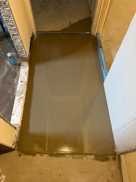 Nybetonggjuten trappa i byggprojekt, omgiven av oskyddade väggar och byggmaterial, under renovering eller konstruktion.