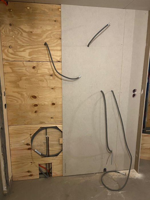 Renovering pågår, gipsvägg och OSB-skivor, elinstallationer ej färdigställda, rör och kablar utsatta.