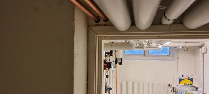 Värmesystem, rör, radiator, interiör, installationsrum, kopparledningar, ventiler, fönster, tekniskt utrymme, belysning, ljus, skrymmande.