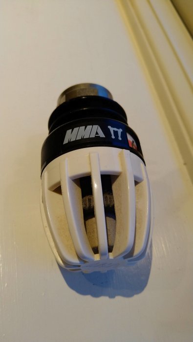 Energisparande spiralformad kompaktlysrör med vit plastsockel mot ljus bakgrund.
