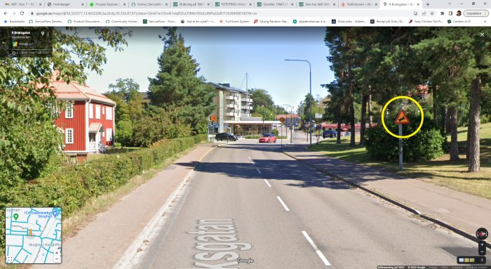 Stadsmiljö, trafik, rött hus, träd, skylt för vägarbete, buss, blå himmel, Google Street View-interface.