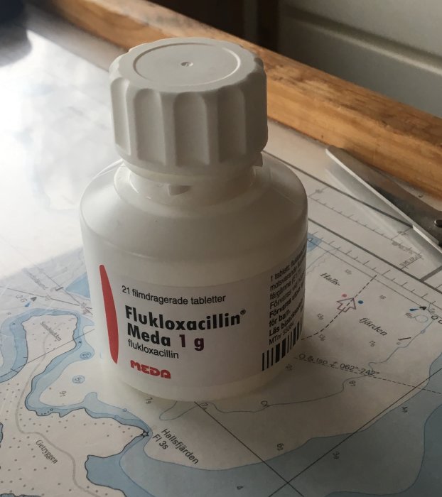 Flukloxacillin Meda 1g antibiotikum i vit flaska på blå kartbakgrund. Säkerhetskork. Medicin eller hälsorelaterat.