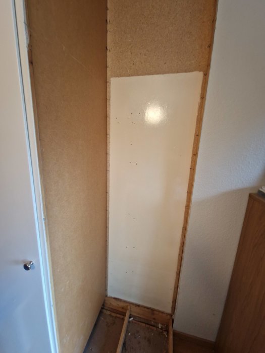 Renovering pågår, vägg avlägsnad lämnande exponerat trä och oskyddad isolering.