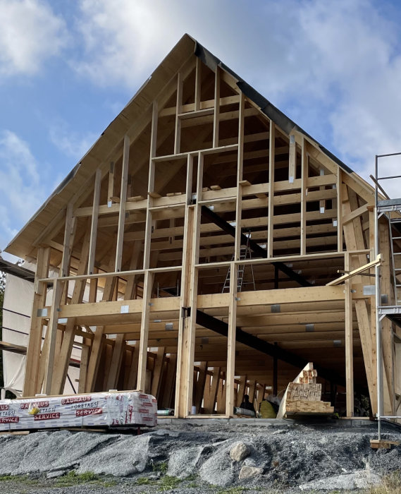 Trästomme för hus under konstruktion, byggmaterial, blå himmel, ställning, dagtid.