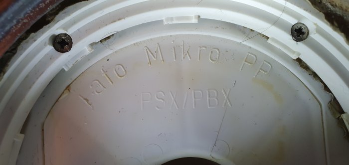 Närbild, vit plast, text "Iafo Mikro PP", skruvar, röranslutning, smuts, använda komponenter.