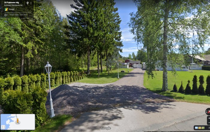 Grusväg, träd, häck, gräsmatta, ljusstolpe, hus i bakgrunden, klart väder, Google Street View-gränssnitt.