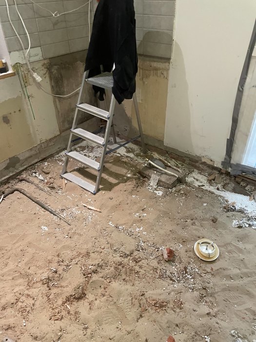 Renoveringsarbete inomhus, stegpall, rör, kablar, röran, byggsopor, avlägsnad vägg- eller golvyta.