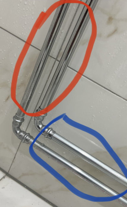 Röda och blåa markeringar, kanske fokus på specifika delar, av en duschkabin eller duschdörrkonstruktion, våta ytor.