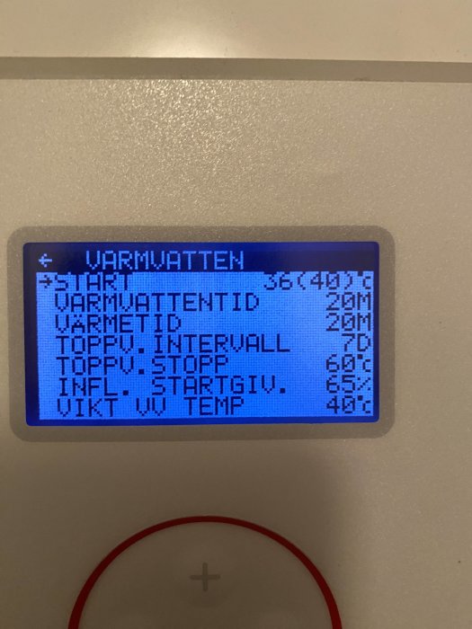 Digital display visar inställningar för varmvatten, inklusive temperatur och tider, på svenska. Blå bakgrundsbelysning.