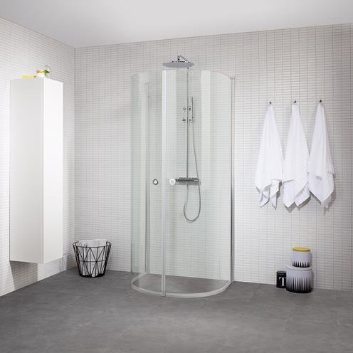 Modernt badrum, duschhörna, vita handdukar, minimalistisk design, grått golv, papperskorg, hygienartiklar.