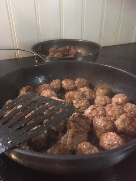 Stekpanna med brynta köttbullar, spatel, matlagning, kök, hemlagat.