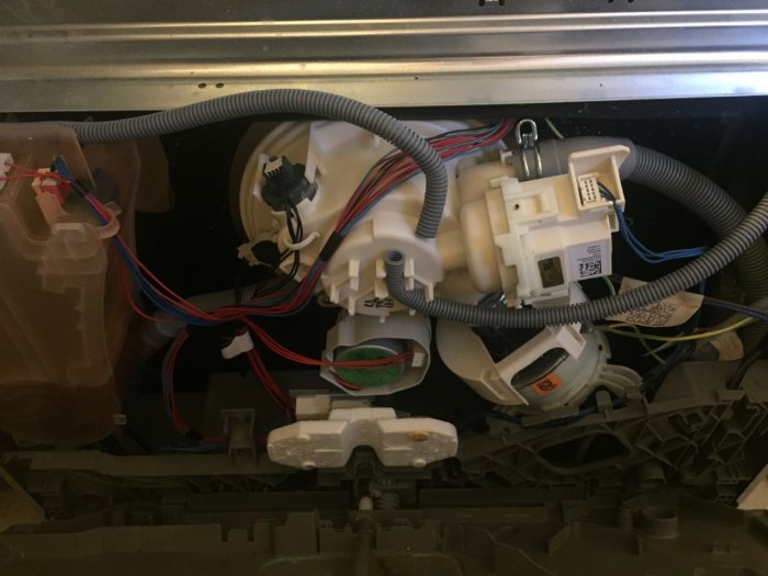 Intern vy av hushållsapparat, elektronik, ledningar, plastkomponenter, ej identifierbart utan kontext.