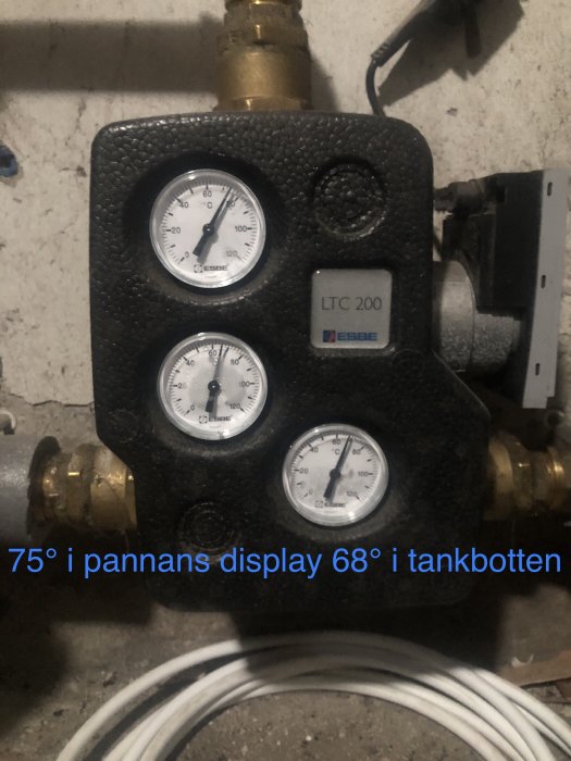 Värmesystemregulator med tre manometrar och en LTC 200-enhet, kablar och rörkopplingar, industriell miljö.