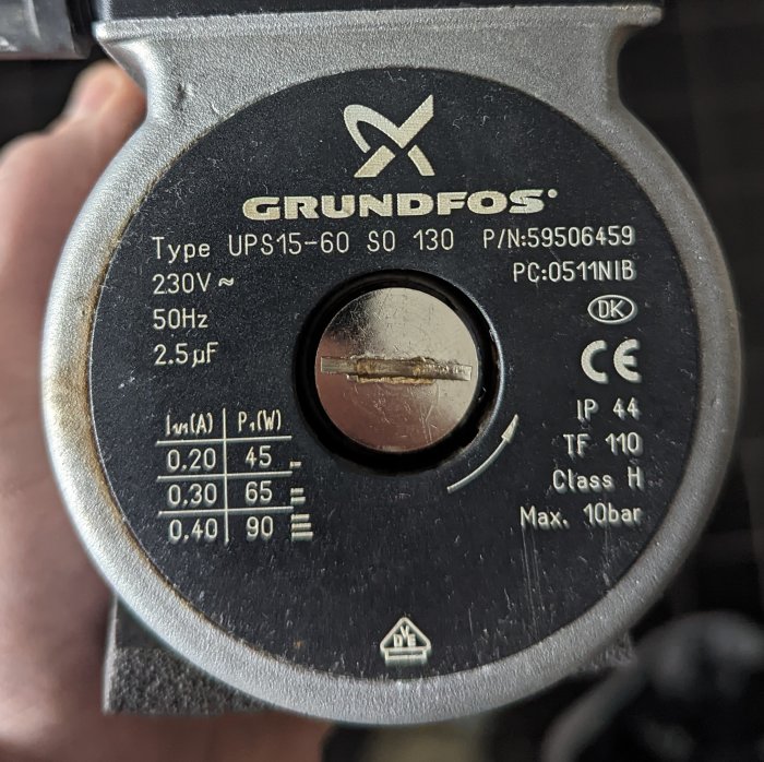 Cirkulationspumpsmärke GRUNDFOS, modell UPS15-60, tekniska specifikationer synliga, förmodligen installations- eller underhållsfoto.