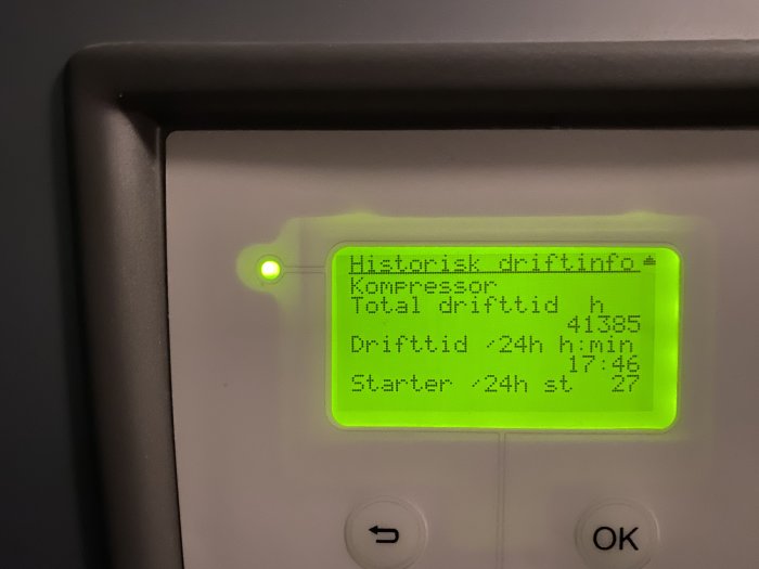 Digitalt display med driftinformation för kompressor, total drifttid, daglig drift och starter. Grön LED-indikator, knappar, svart ram.