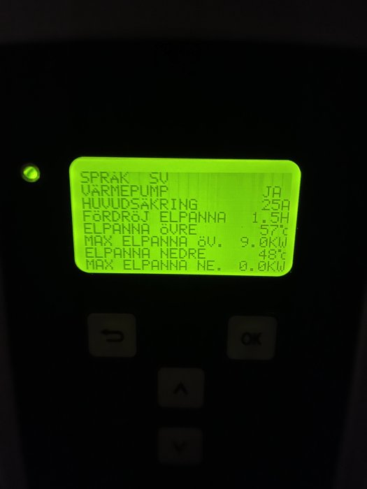 Digital display för värmeanläggning, visar temperatur, språk, fuktcirkulation och elpannan användning, omgiven av knappar.