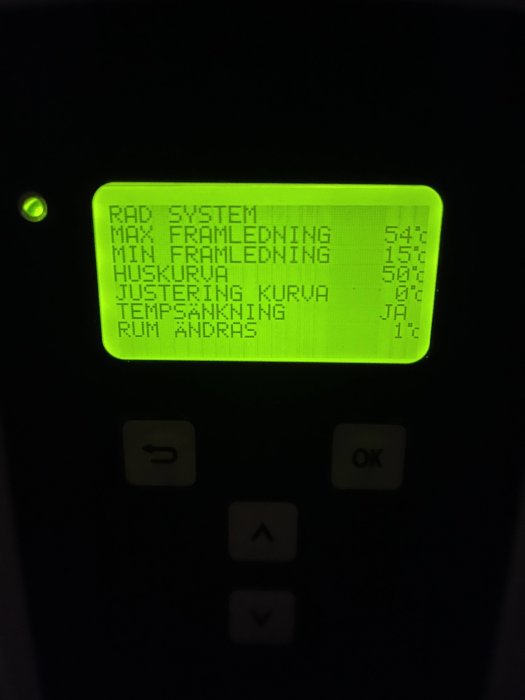 Digital kontrollpanel, grönbelysning, justerbar temperaturinställning, knappar, möjligen för värmesystem eller pannstyrning.