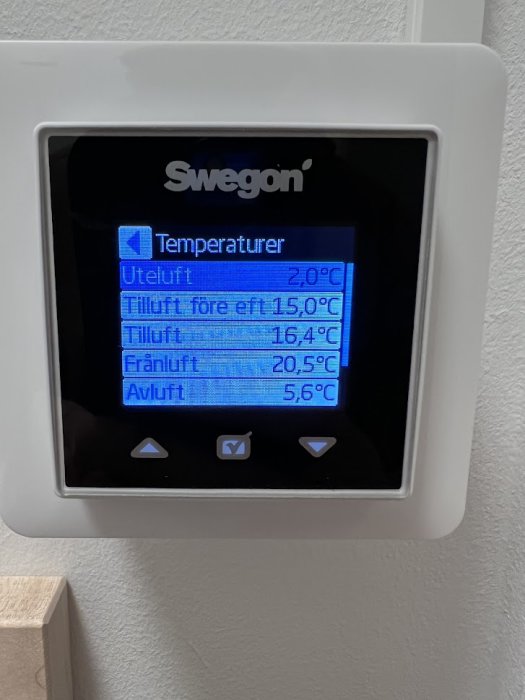 Swegon temperaturkontrollpanel som visar olika lufttemperaturer inomhus och utomhus på en blå bakgrundsbelyst skärm.